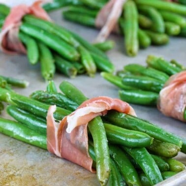 Prosciutto wrapped green beans on a cooking sheet