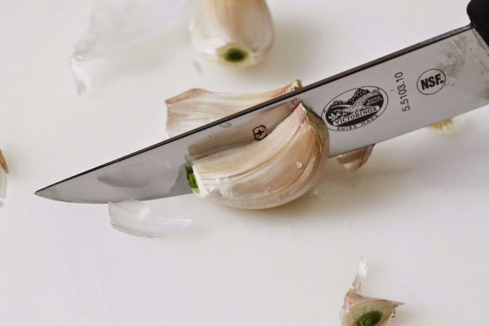 The garlic clove is then sliced in half the long way 