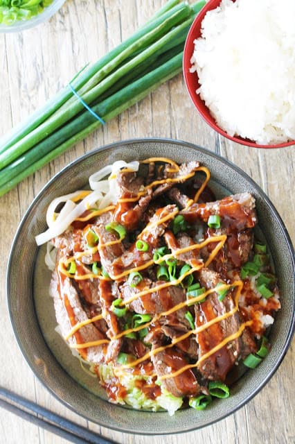 Rice noodles, rice, and cabbage, topped with delicious Korean bulgogi, drizzled with sriracha mayo and Korean barbecue sauce....it's seriously so good!