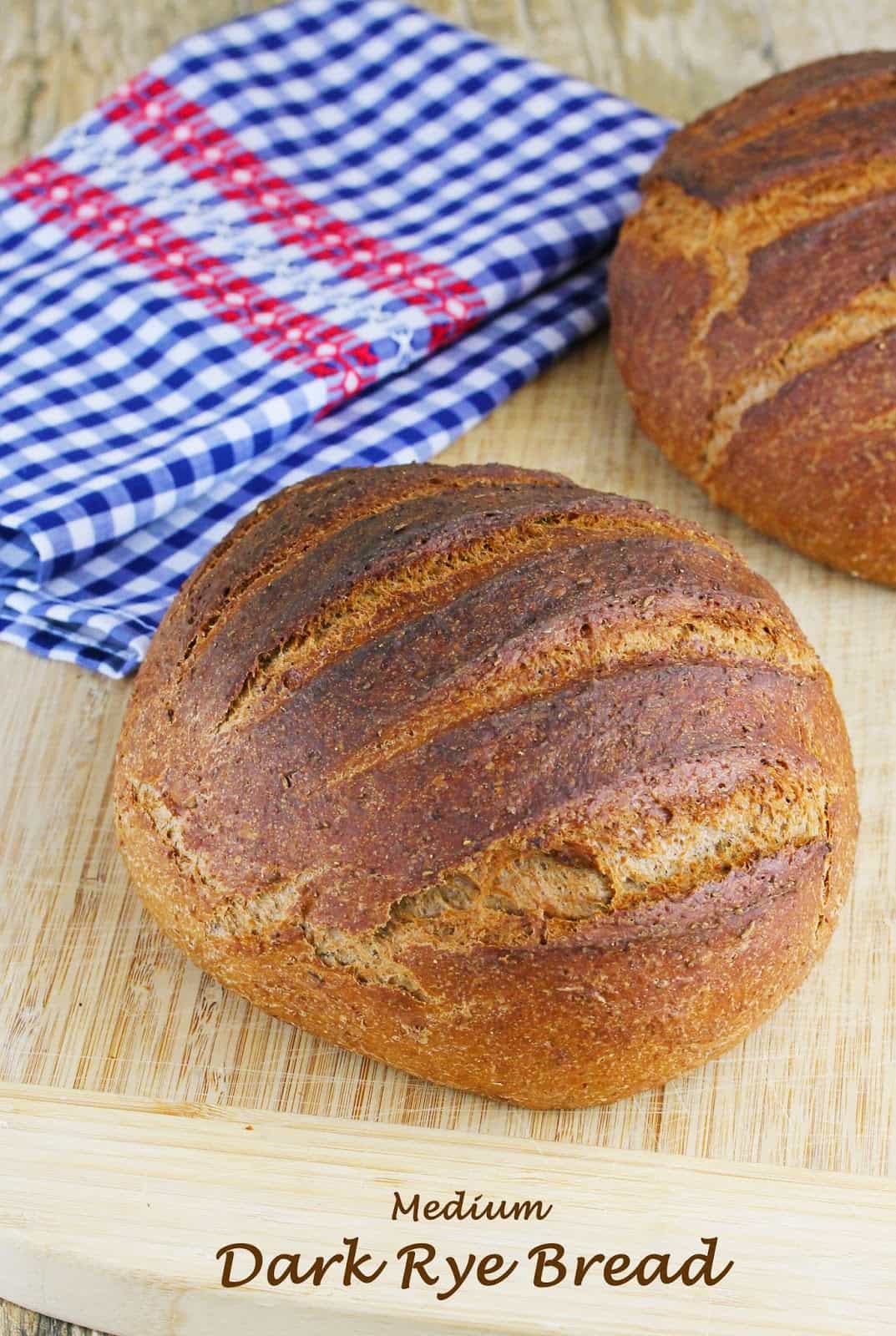Medium Dark Rye Bread: Loaves of freshly baked rye bread on a cutting board with a tea towel