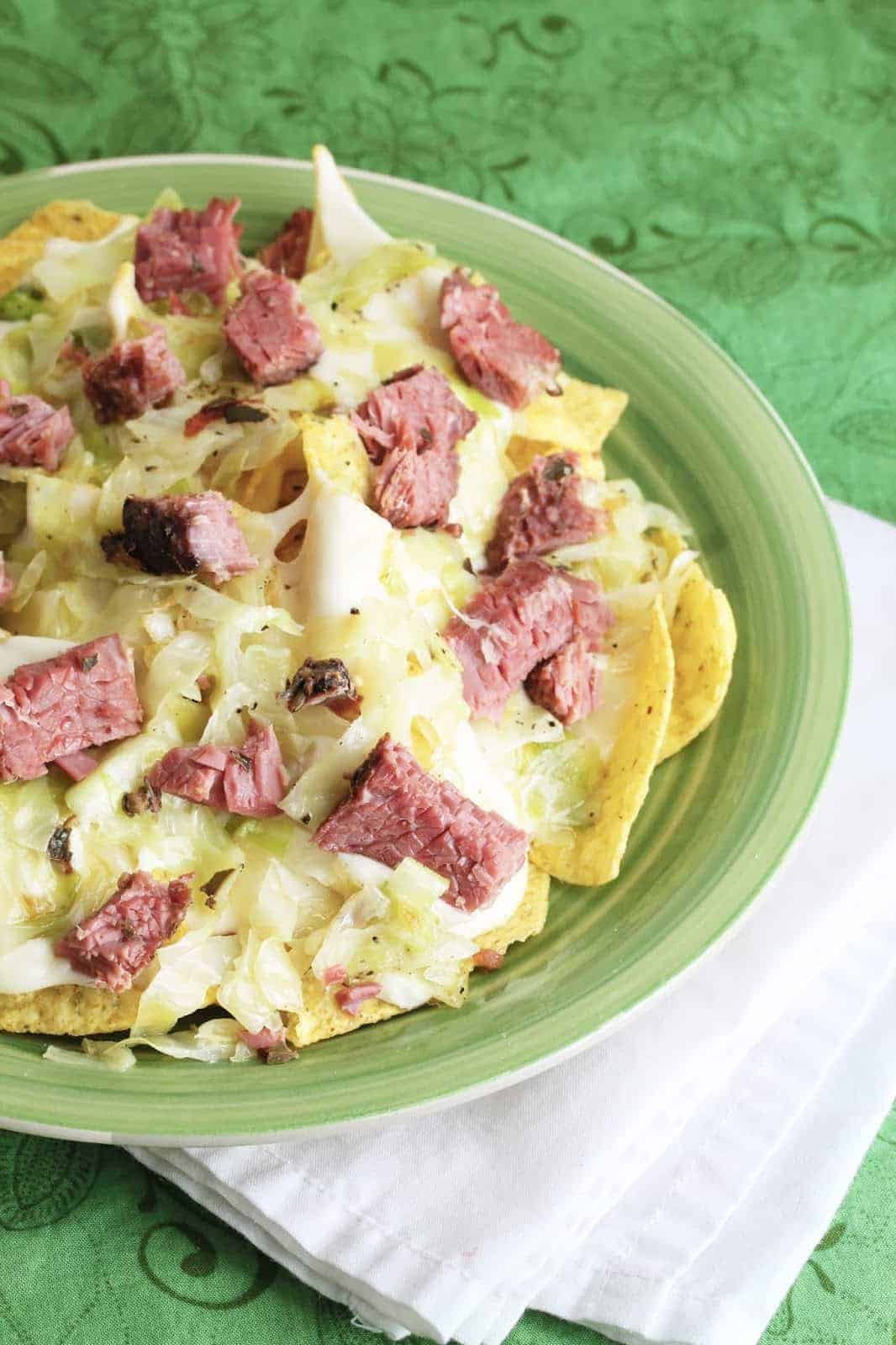 Corned beef and cabbage nachos on a green plate.