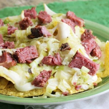 Close up of Corned beef and cabbage nachos on a green plate.