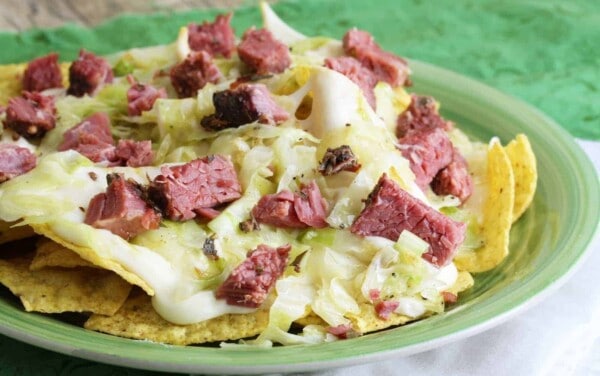 Close up of Corned beef and cabbage nachos on a green plate.