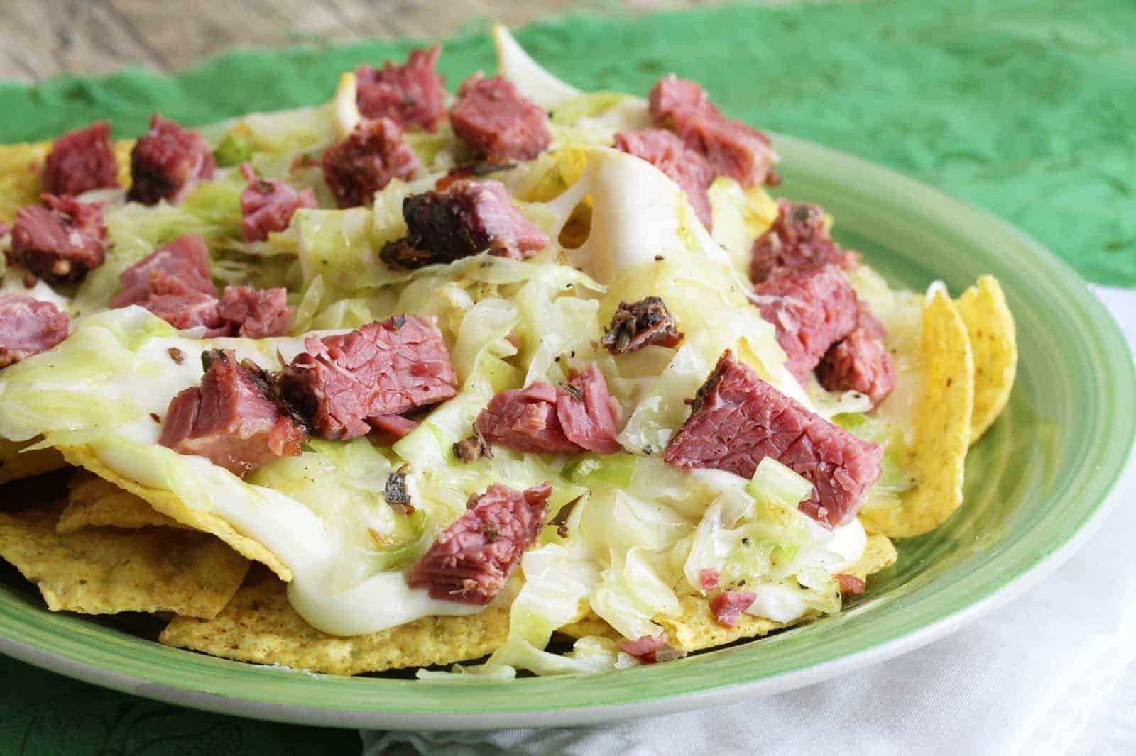 Close up of Corned beef and cabbage nachos on a green plate.