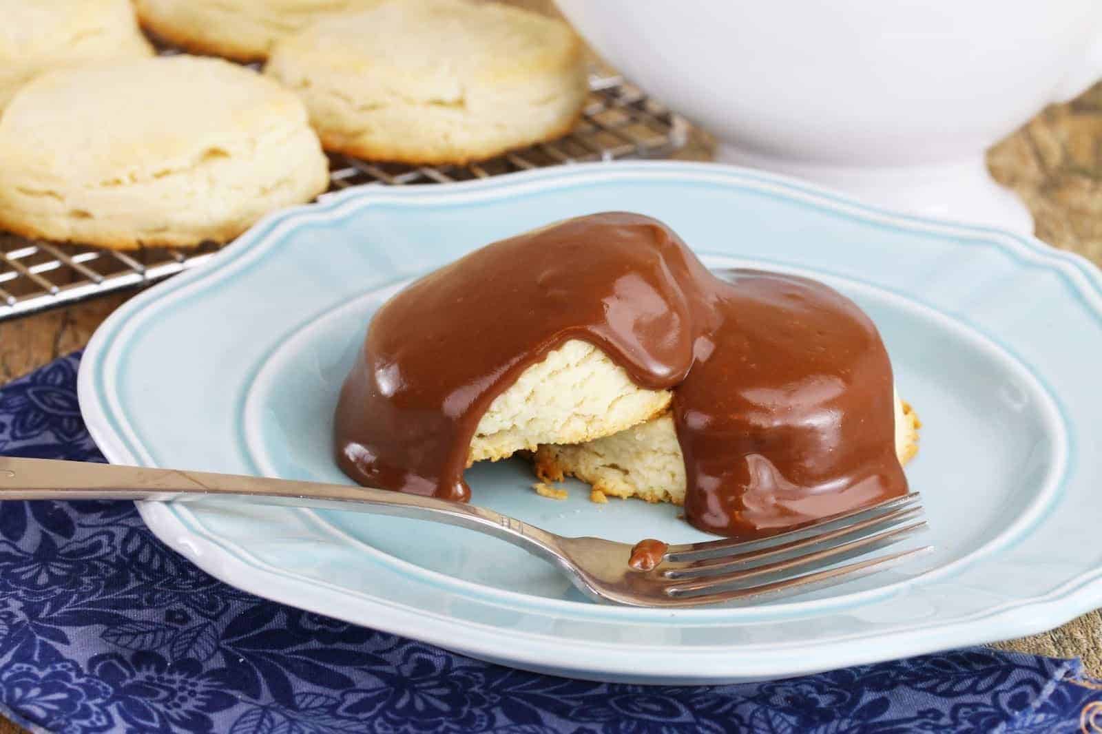 A couple of sweet biscuits on a plate, drizzled with chocolate gravy