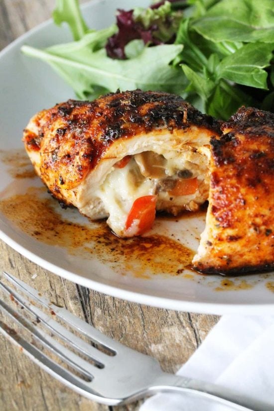 Cajun stuffed chicken breast sliced open with warm melty cheese and peppers oozing out