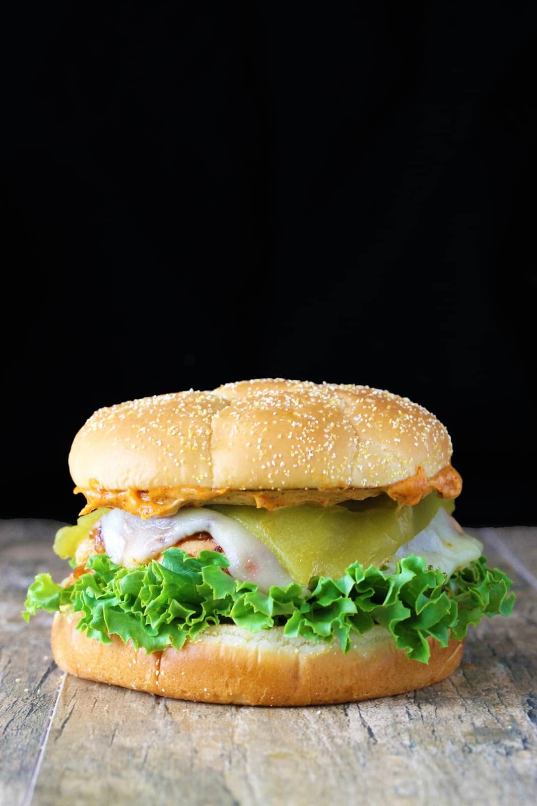 Santa fe chicken sandwich on a wooden table with a black background
