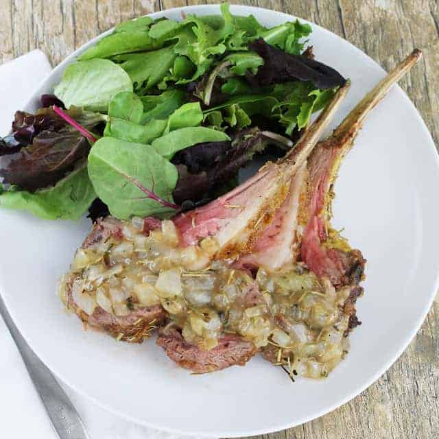 Bird's eye view of Mustard Crusted Lamb Topped With Herb Sauce and side of salad