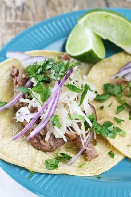 Cuban mojo pork tacos with raw red onions and cilantro on top