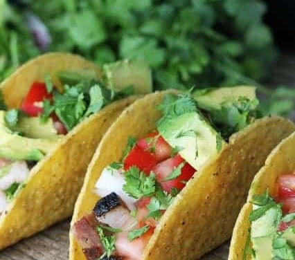 Close up on three ancho chili pork belly tacos.