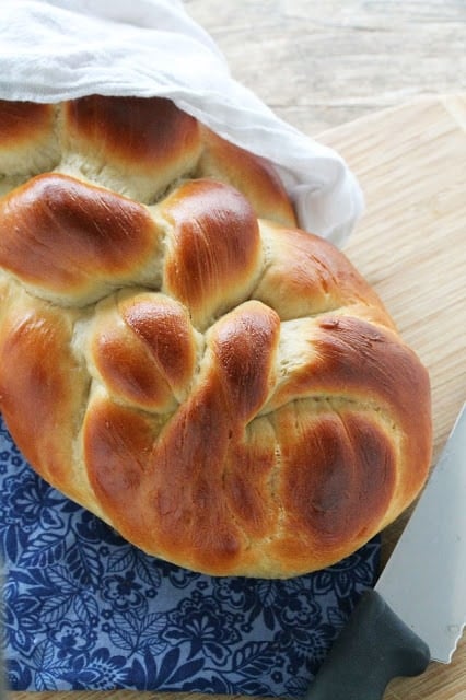 Challah Bread semi wrapped in a white towel.