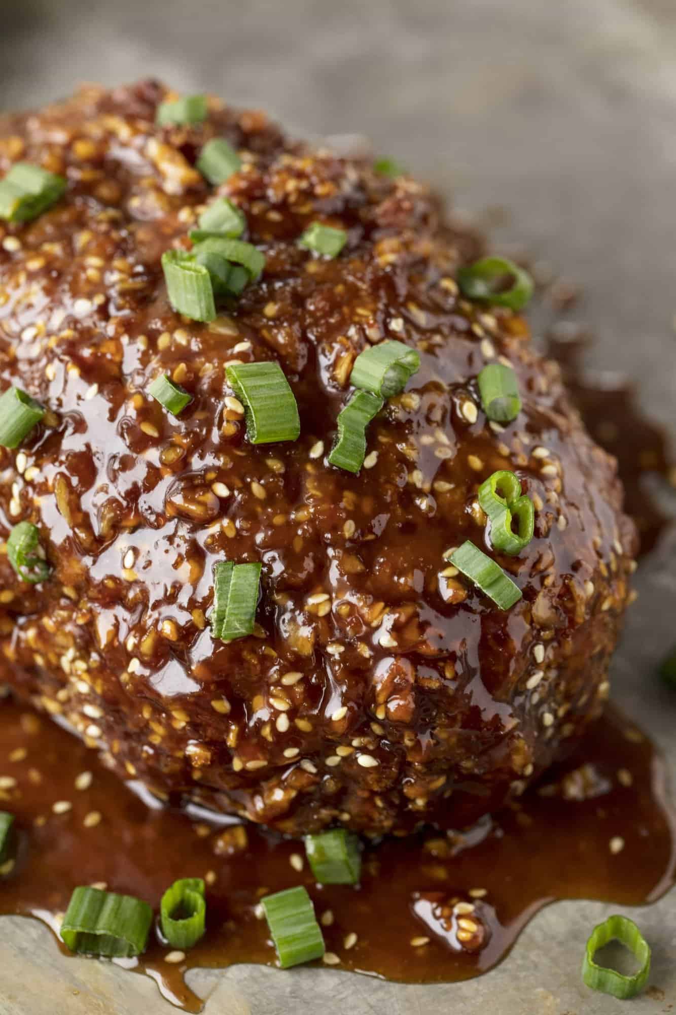 Close up of a Korean Meatloaf topped with a glaze and green onions.