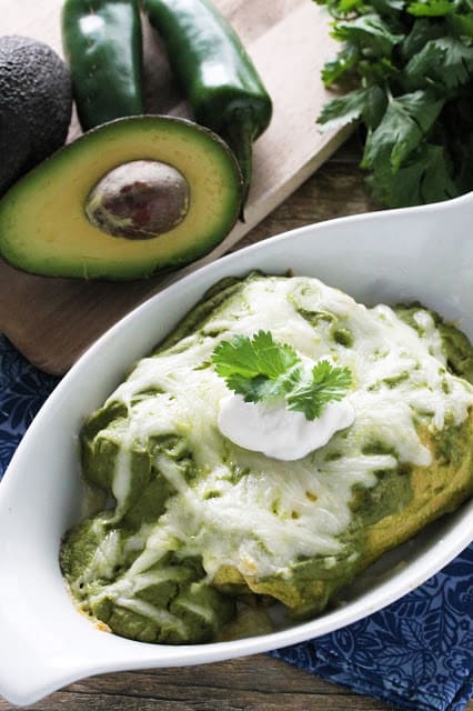 Mole Verde Chicken Enchiladas are stuffed with flavorful chicken and avocado, then smothered in a delicious green mole sauce.