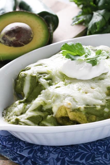 Mole Verde Chicken Enchiladas are stuffed with flavorful chicken and avocado, then smothered in a delicious green mole sauce.