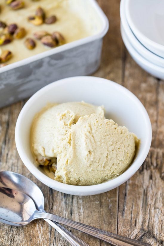 Homemade pistachio gelato in a small bowl with spoons next to it