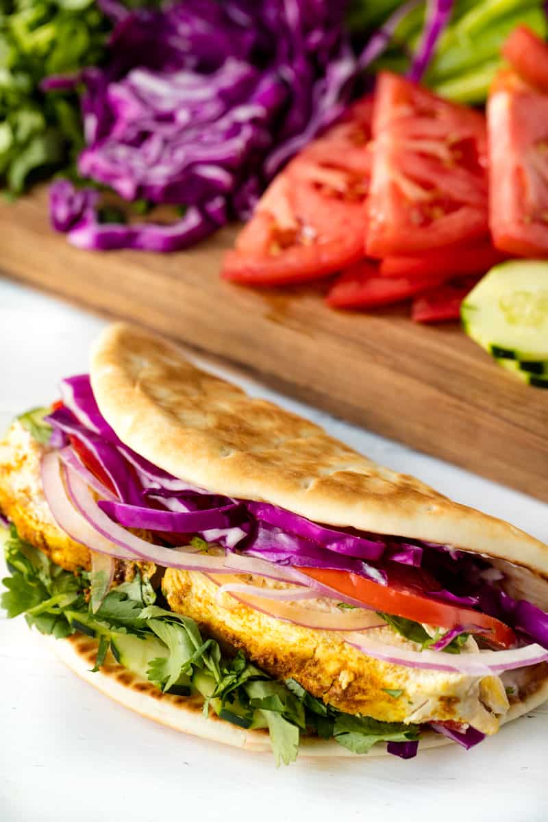 spiced chicken breasts sliced and served gyro style with tons of vegetables and topped off Moroccan Chicken Gyros