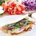 Moroccan-spiced chicken breasts sliced and served gyro style with tons of vegetables and topped off with a zingy tahini sauce.