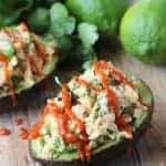 Avocado halves stuffed with Thai-inspired tuna, garnished with chopped cilantro and drizzled with spicy Asian chili sauce