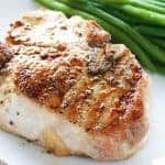 Thick cut juicy bone-in pork chop with a side of green beans