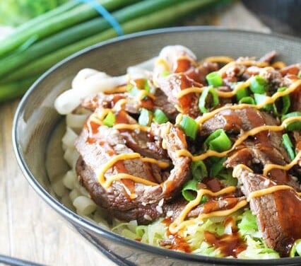 Rice noodles, rice, and cabbage, topped with delicious Korean bulgogi, drizzled with sriracha mayo and Korean barbecue sauce....it's seriously so good!