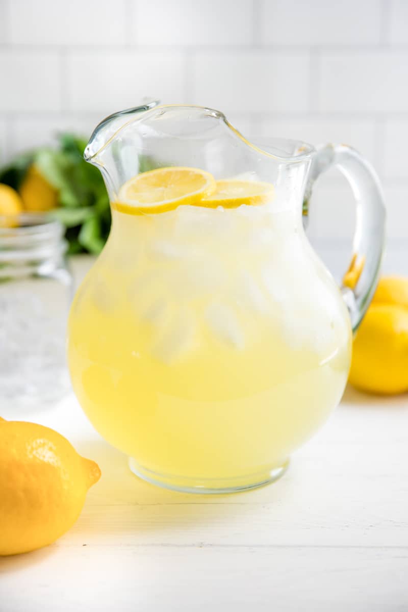 Homemade Lemonade in a glass pitcher with fresh lemon slices.