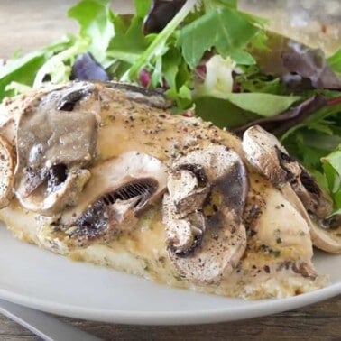 Mushroom covered baked chicken covered in honey-dijon sauce with greens