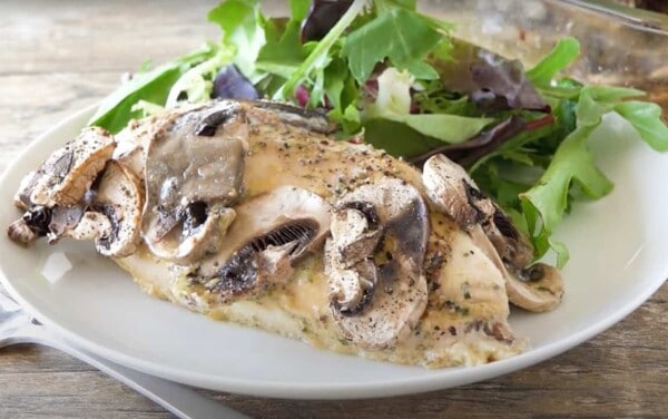 Mushroom covered baked chicken covered in honey-dijon sauce with greens