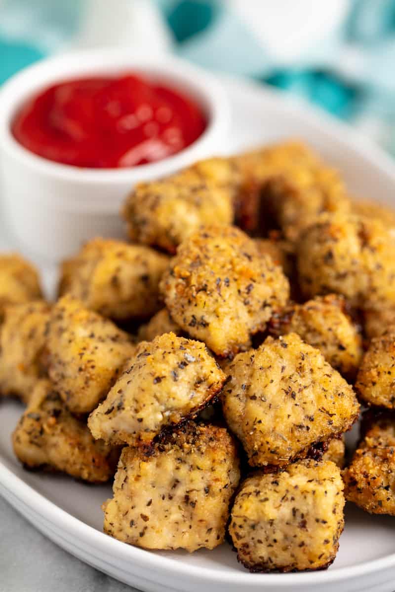 White Plate full of Chicken Nuggets and a cup of ketchup.