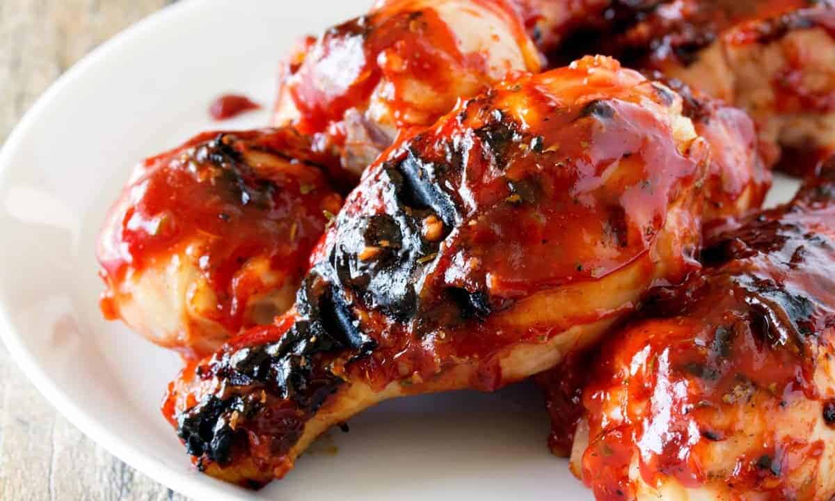Angled view of Hickory Smoked BBQ Chicken Drumsticks on white plate.
