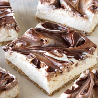 Close-up view of light and fluffy cheesecake swirled with creamy Nutella sits on top of a graham cracker crust.
