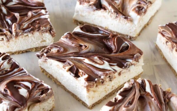 Close-up view of light and fluffy cheesecake swirled with creamy Nutella sits on top of a graham cracker crust.