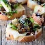Brussel Sprout and Brie Bruschetta on a wood countertop.