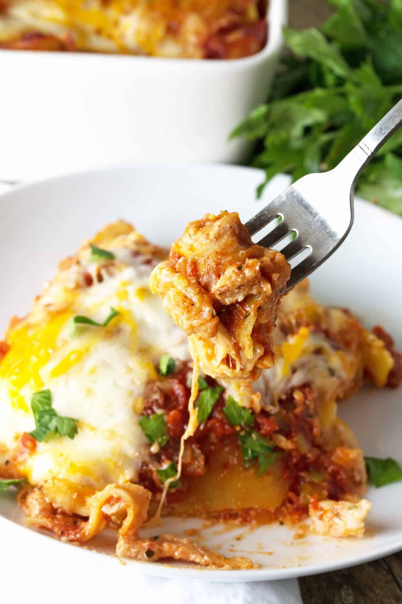 A fork is holding a piece of Cajun Shrimp Lasagna.