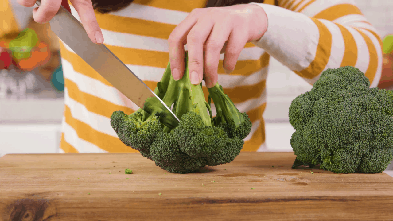 Cutting broccoli with the stem facing up.