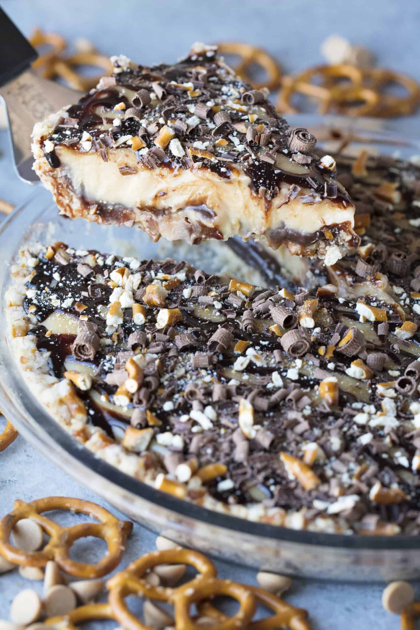 A slice lifted out of a Peanut Butter Fudge Pie with Pretzel Crust