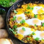 Sheepherder's Breakfast in a cast-iron skillet with potatoes and onions around the skillet.