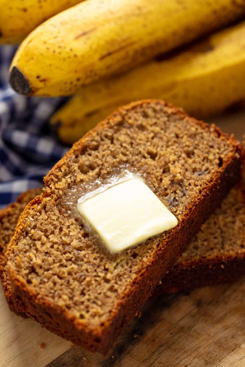 A slice of Banana Bread with a pad of butter melting on it.