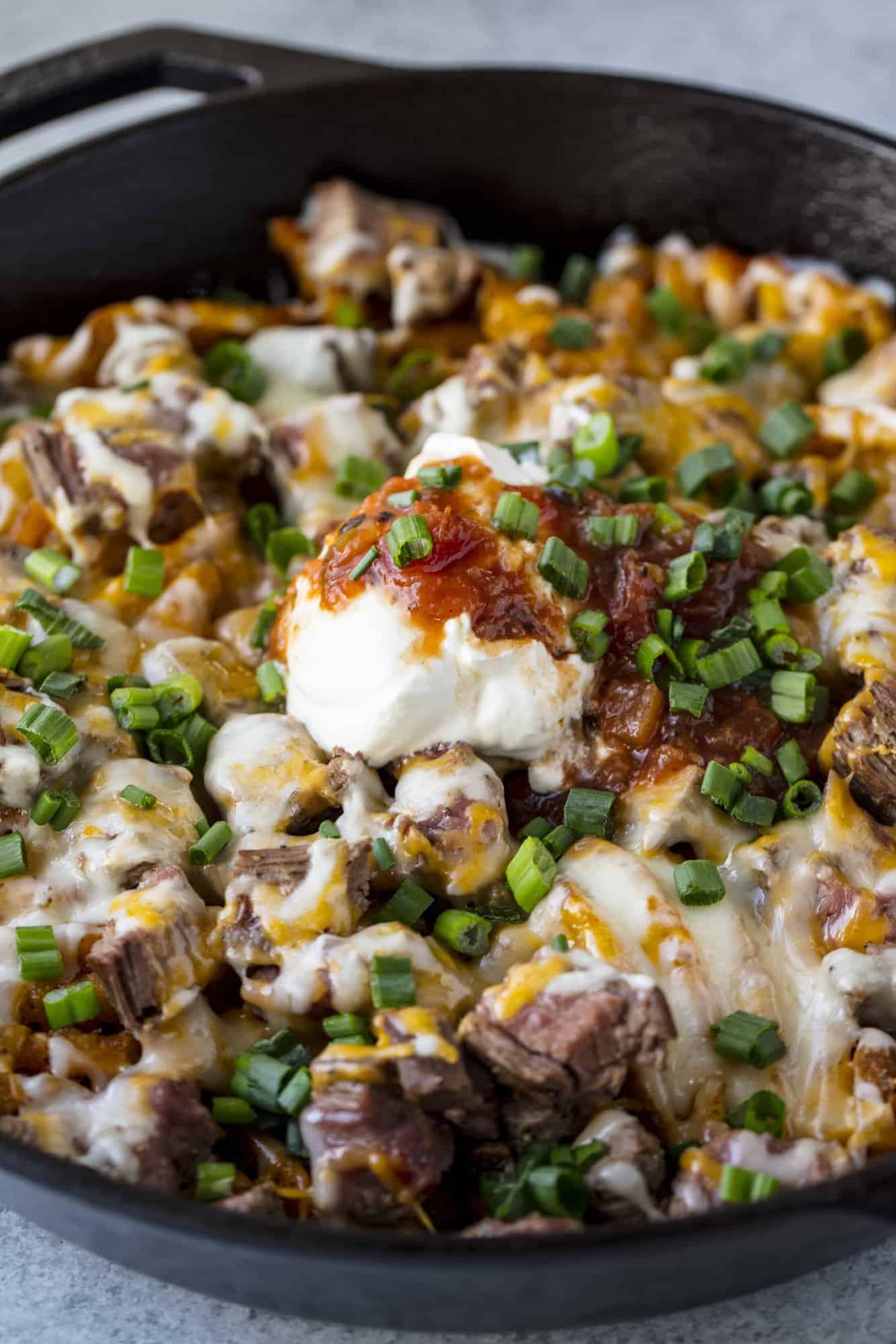 Steak and Potato Nachos combine three of your favorite comfort foods into one amazing and indulgent skillet dish. Eat it as a drool-worthy appetizer, or as a hearty and full dinner.