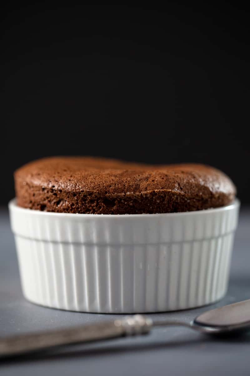 chocolate souffle in a white ramekin dish.