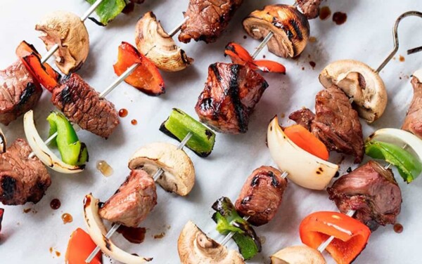 Five Marinated Steak Kebabs on parchment paper.