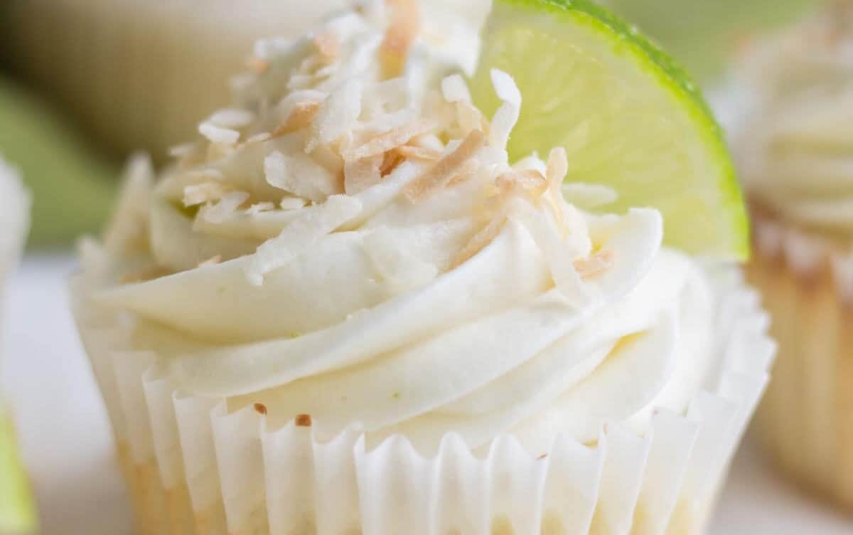 Coconut lime cupcake topped with toasted coconut, and a quarter slice of lime