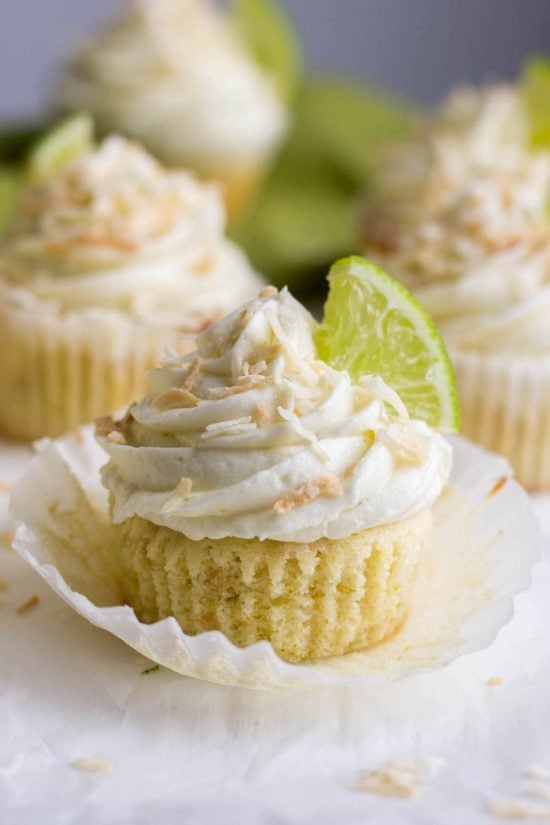 Coconut lime cupcake topped with toasted coconut, and a quarter slice of lime