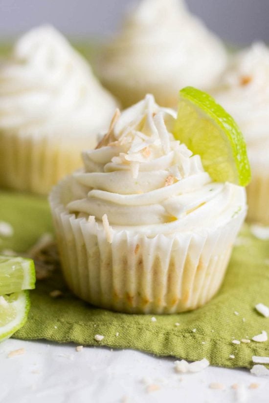 Coconut lime cupcake topped with toasted coconut, and a quarter slice of lime