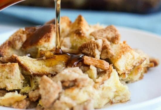 Cinnamon toast crunch breakfast casserole on a white plate getting syrup poured on it.