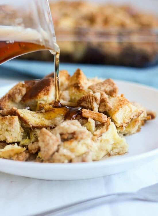 Cinnamon toast crunch breakfast casserole on a white plate getting syrup poured on it.
