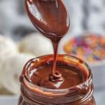 Spoon drizzling in Hot Fudge sauce into a mason jar full of hot fudge.