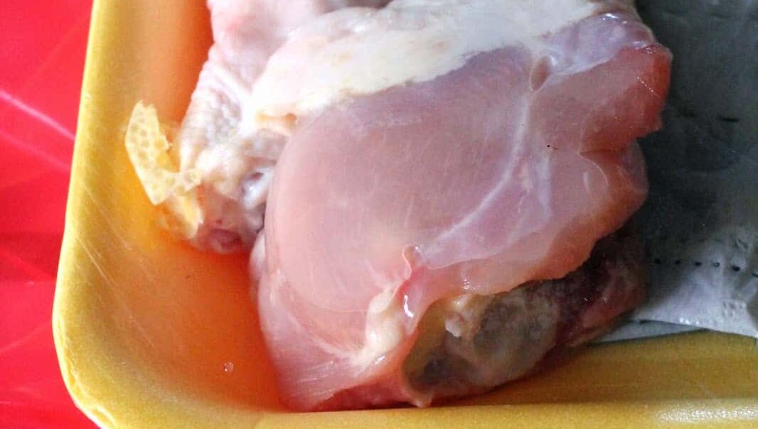 raw chicken drumsticks with skin folded back