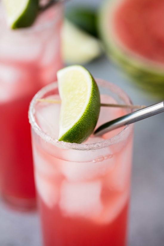 Key west cooler mocktail in a slender glass cup, lip lined with sour sugar and an a lime slice on top