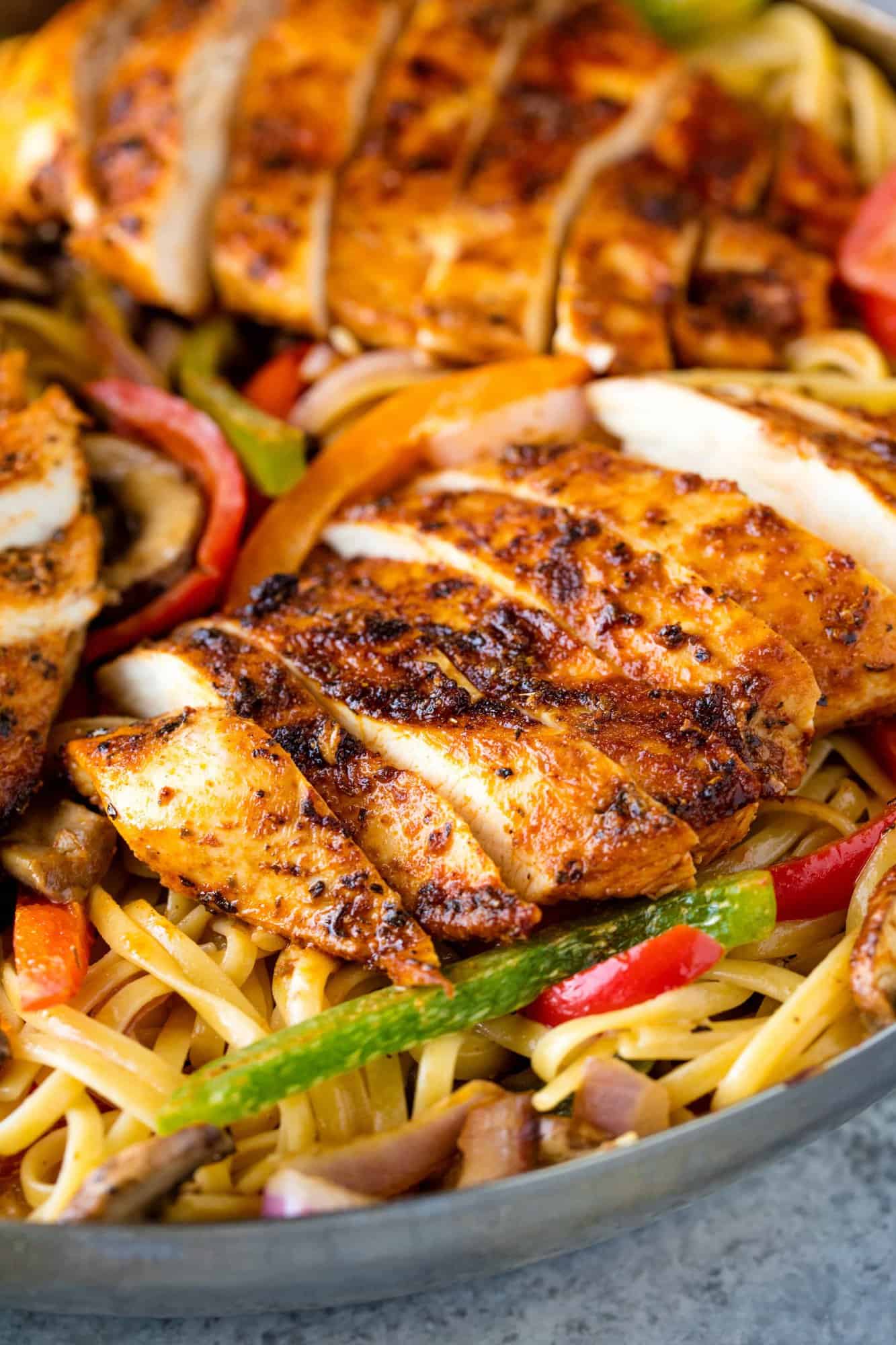 Creamy Cajun Chicken Pasta is the perfect family meal. Juicy cajun-spiced chicken is served over a bed of creamy pasta that's packed full of sautéed veggies.