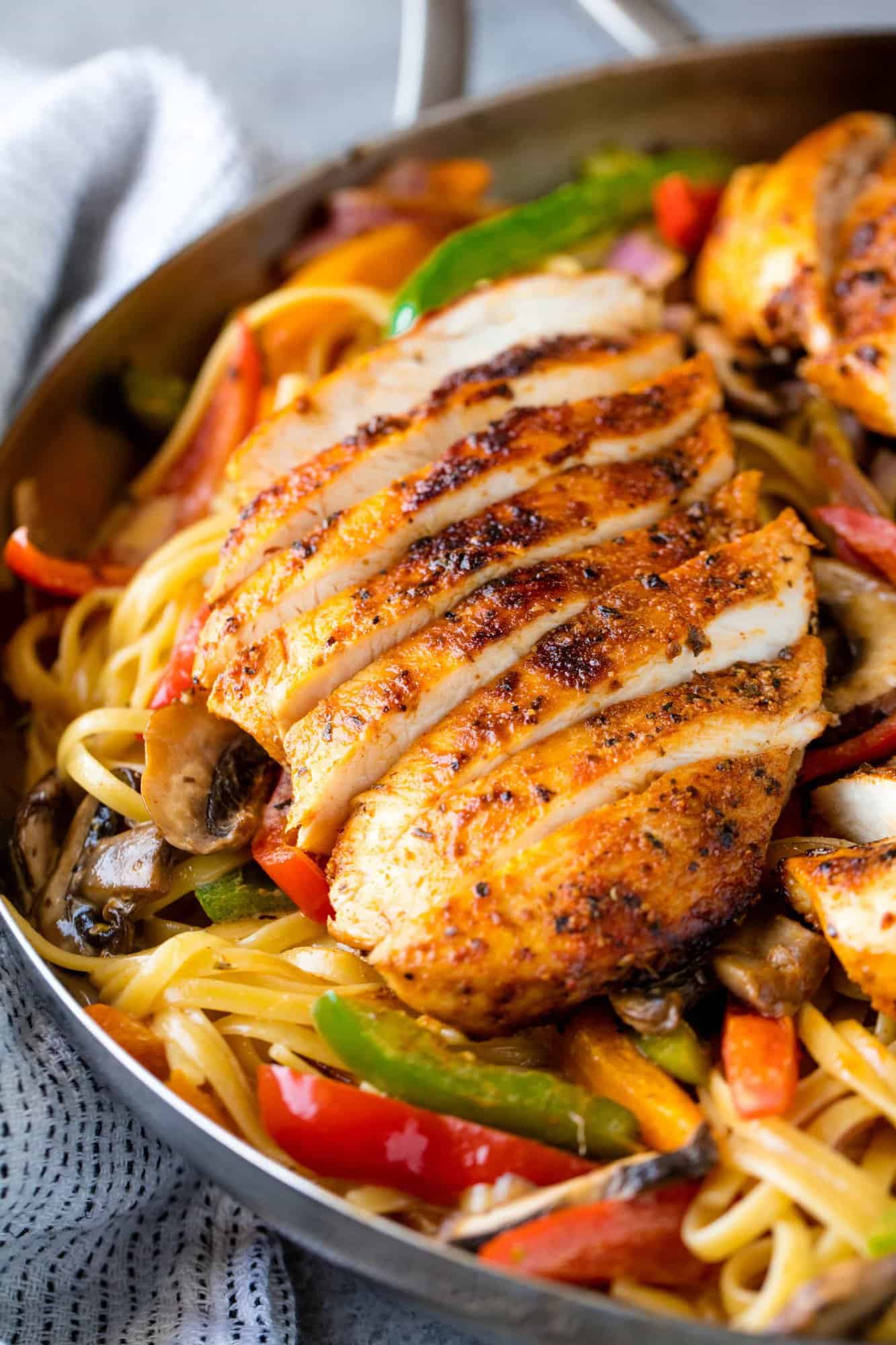 Creamy Cajun Chicken Pasta is the perfect family meal. Juicy cajun-spiced chicken is served over a bed of creamy pasta that's packed full of sautéed veggies.